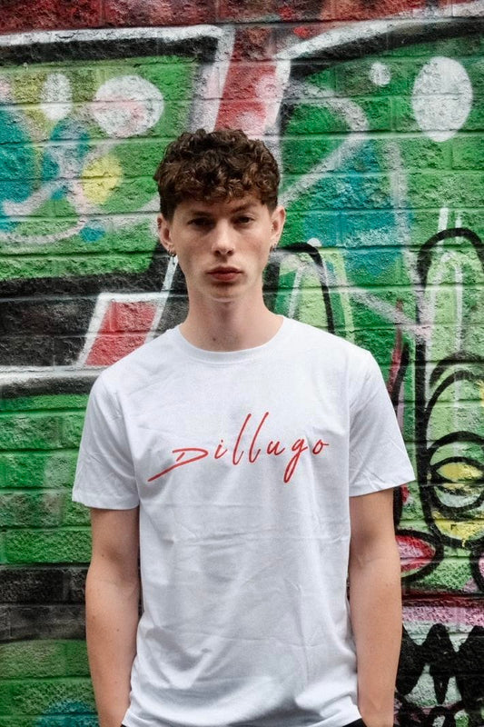 Male model wearing white t-shirt with "Dillugo" written across it (in red) on a graffiti backdrop.